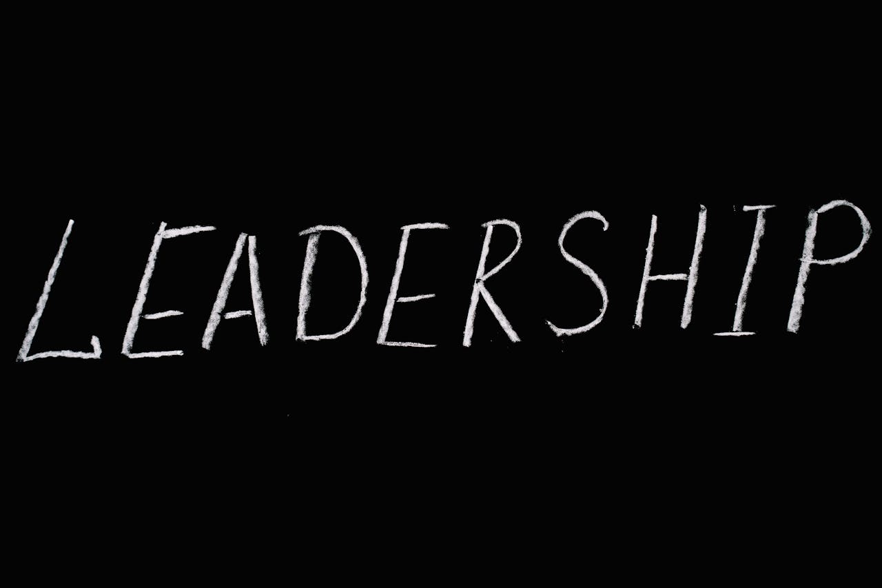 Chalk text spelling Leadership on a blackboard, symbolizing guidance and authority.